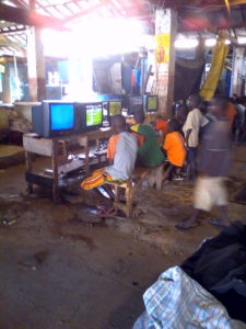 Crianças a jogar Playstation no mercado de tambarina